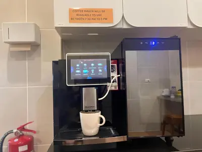 a coffee machine with a cup on a counter at The Rock Poshtel Patong in Patong Beach