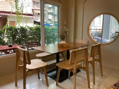 a dining room with a table and chairs and a mirror at The Rock Poshtel Patong in Patong Beach