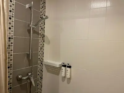 a bathroom with a shower with a glass door at The Rock Poshtel Patong in Patong Beach