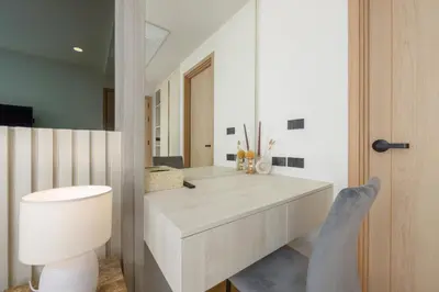 a bathroom with a vanity with a toilet and a mirror at Suite Salina 2BR Pool Gym Access Ozone in Laguna Phuket
