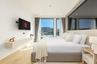 a bedroom with a large bed and a large window at Suite Salina 2BR Pool Gym Access Ozone in Laguna Phuket