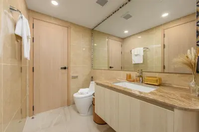 a bathroom with a sink and a toilet and a shower at Suite Salina 2BR Pool Gym Access Ozone in Laguna Phuket