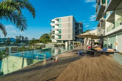 a swimming pool in front of a building with a building at Resort Sea View Apartment Patong in Patong Beach