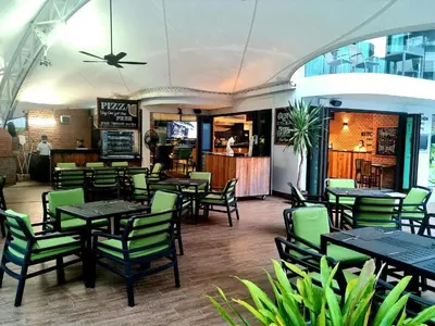 a restaurant with green chairs and tables and a bar at Resort Sea View Apartment Patong in Patong Beach