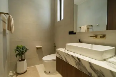 a bathroom with a sink and a toilet and a mirror at Grand View Family Villa 5 min to Beach in Ban Thalat Choeng Thale