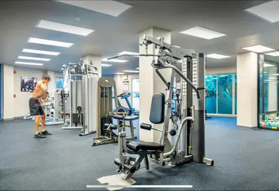 a gym with several tread machines and a man standing in it at Karon Beach Forest View in Ban Karon