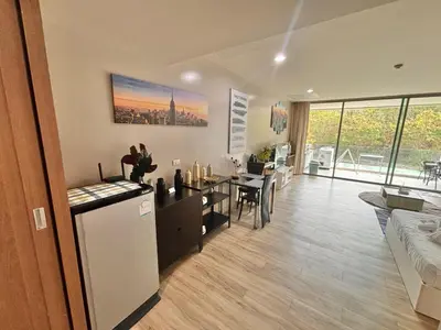a living room with a kitchen and a dining room at Karon Beach Forest View in Ban Karon