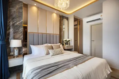 a bedroom with a large bed and a chandelier at Bellevue Lagoon by My Home Phuket in Laguna Phuket