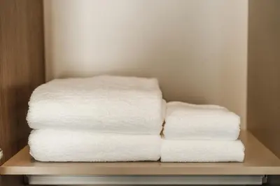 a stack of white towels sitting on a shelf at Condo Close to the Beach and City Center in Laguna Phuket