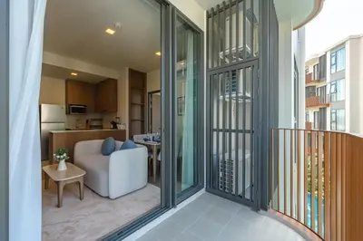 a balcony with a living room and a kitchen at Condo Close to the Beach and City Center in Laguna Phuket