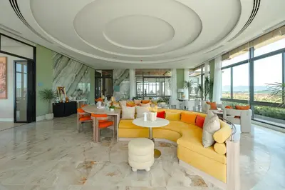 a living room with a yellow couch and a table at Condo Close to the Beach and City Center in Laguna Phuket