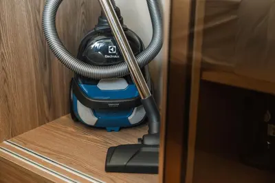 a vacuum cleaner hanging from a wooden door at Condo Close to the Beach and City Center in Laguna Phuket