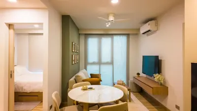 a small living room with a table and a bed at Apartment 2 bedrooms in SkyPark in Laguna Phuket