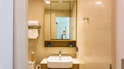 a bathroom with a sink and a mirror and a toilet at Apartment 2 bedrooms in SkyPark in Laguna Phuket