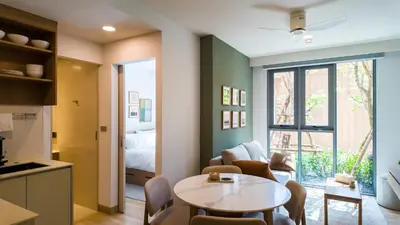 a kitchen and a living room with a table and chairs at Apartment 2 bedrooms in SkyPark in Laguna Phuket