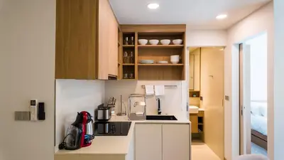 a kitchen with white cabinets and a counter top at Apartment 2 bedrooms in SkyPark in Laguna Phuket