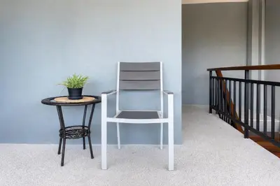 a chair and a table with a plant on it at The Homey Boutique Rawai in Ban Nong Chaeng