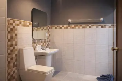 a bathroom with a toilet and a sink and a mirror at The Homey Boutique Rawai in Ban Nong Chaeng