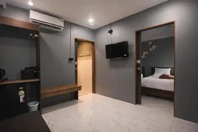 a bedroom with a bed and a mirror and a television at The Homey Boutique Rawai in Ban Nong Chaeng