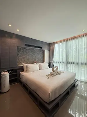 a bedroom with a large bed with a large window at Citygate condo at Kamala Beach in Kamala Beach