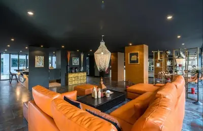 a living room with orange furniture and a chandelier at Citygate condo at Kamala Beach in Kamala Beach