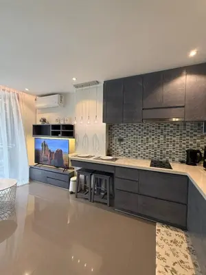 a kitchen with black cabinets and a counter top at Citygate condo at Kamala Beach in Kamala Beach