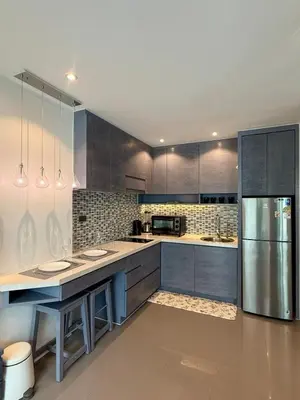 a kitchen with gray cabinets and a stainless steel refrigerator at Citygate condo at Kamala Beach in Kamala Beach