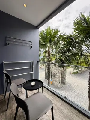 a room with a table and chairs and a large window at Citygate condo at Kamala Beach in Kamala Beach