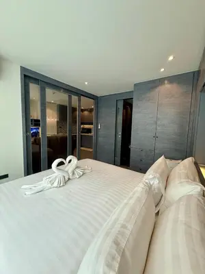 a white ribbon sitting on top of a bed at Citygate condo at Kamala Beach in Kamala Beach