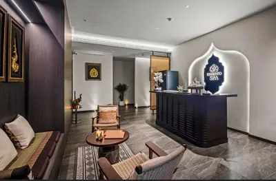 a hotel lobby with a fireplace and a table and chairs at Sunshine Layan Beach Resort 1 bedroom #84196 in Layan Beach