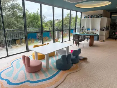 a living room with a table and chairs and windows at Sunshine Layan Beach Resort 1 bedroom #84196 in Layan Beach