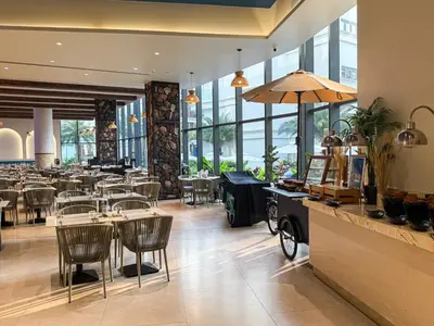 a restaurant with tables and chairs and windows at Sunshine Layan Beach Resort 1 bedroom #84196 in Layan Beach