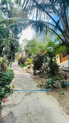 a garden with a blue hose on a dirt road at บ้านสกุลลี-House of Lee in Ban Huai Sai