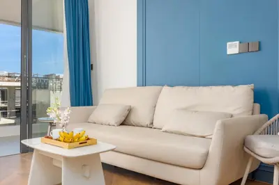 a living room with a white couch and a table at Hydra 1BR Suite at Kora Beach Resort in Layan Beach