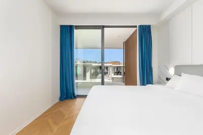 a bedroom with a large bed and a large window at Hydra 1BR Suite at Kora Beach Resort in Layan Beach