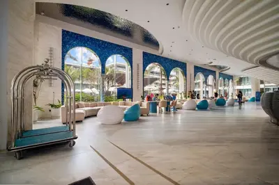 a lobby with blue walls and couches in a building at Hydra 1BR Suite at Kora Beach Resort in Layan Beach