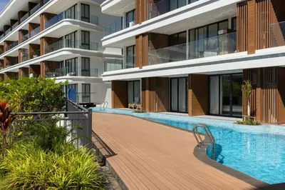 a swimming pool in front of a building at Hydra 1BR Suite at Kora Beach Resort in Layan Beach