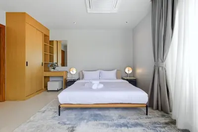 a bedroom with a large white bed with white sheets at Botanica Pru Jampa by Beringela in Phuket
