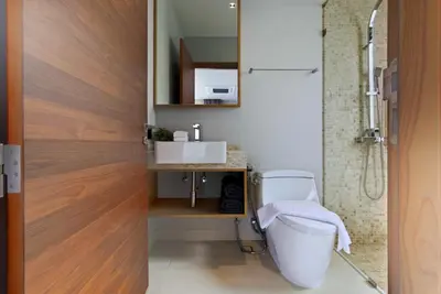 a bathroom with a toilet and a sink at Botanica Pru Jampa by Beringela in Phuket