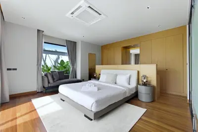 a bedroom with a large white bed and a couch at Botanica Pru Jampa by Beringela in Phuket