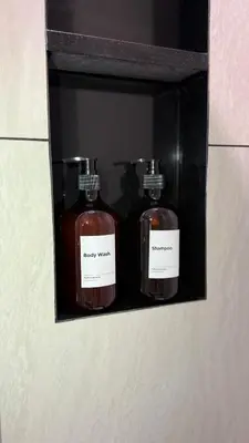 three bottles of soap on a shelf in a bathroom at Cozy Apartment 1 km to Bangtao beach in Bang Tao Beach