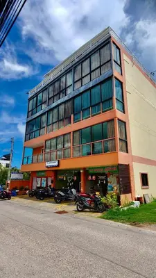 a large building with motorcycles parked in front of it at TK Apartment By Wijitra in Ban Saiyuan (1)
