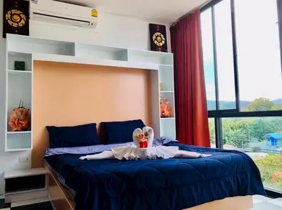 a woman laying on a bed in a bedroom at TK Apartment By Wijitra in Ban Saiyuan (1)