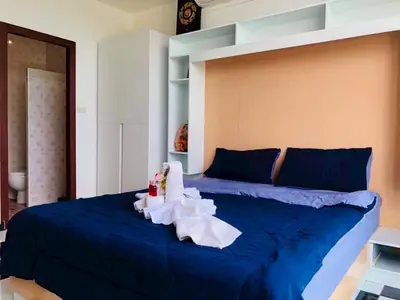 a bedroom with a blue bed with a blue comforter at TK Apartment By Wijitra in Ban Saiyuan (1)