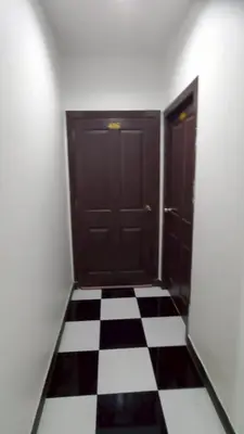 an empty room with two doors and a checkered floor at TK Apartment By Wijitra in Ban Saiyuan (1)