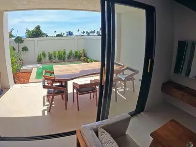 a dining room with a table and chairs on a patio at Rawai 2 Bedrooms Private Pool Villa in Ban Saiyuan (1)