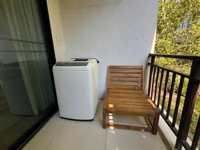 a trash can and a wooden bench on a balcony at Apartment Title II, Rawai Phuket in Rawai Beach