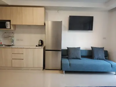 a living room with a blue couch and a refrigerator at CC620 View of Green Hills in Ban Mai Salae