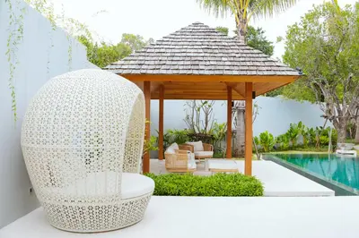 a white wicker gazebo next to a pool at Anchan Flora Luxury 2BR Pool Villa in Thalang