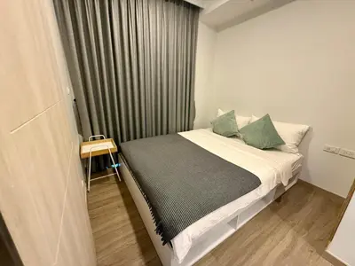 a small bedroom with a bed with green pillows at Laguna cozy 2 bedroom apartment 5min to the beach in Laguna Phuket